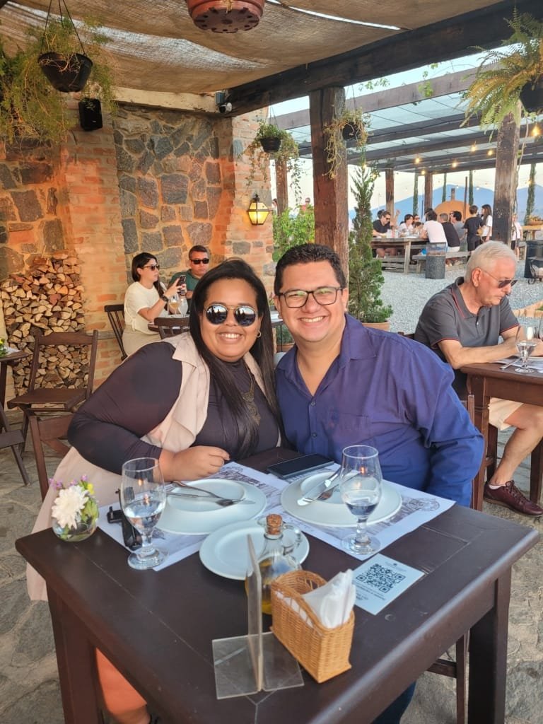 Casal brindando ao pôr do sol na Pizzaria Borgo Del Vino