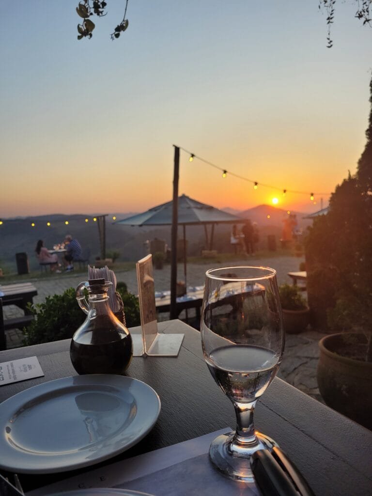 Mesa com taças e pôr do sol no Borgo del Vino Areal