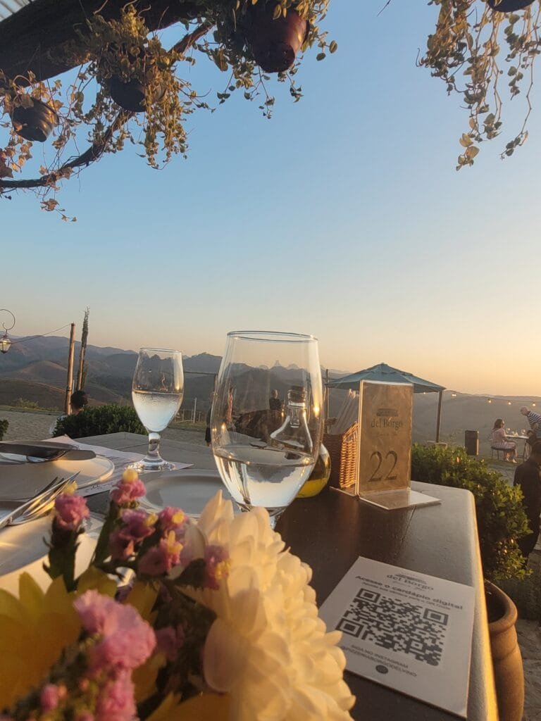 Taças de vinho ao pôr do sol no Borgo del Vino em Areal com vista para montanhas da Serra Fluminense