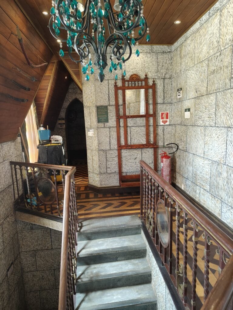 Corredor interno com escada e decoração medieval no Castelo de Itaipava