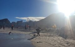 Copacabana Beach in Rio de Janeiro on a sunny day, with people walking along the sand