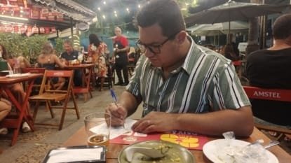 Casal carioca avaliando bares do Comida di Buteco RJ 2024 durante o concurso