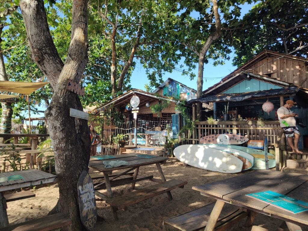 Rua de areia com lojas e artesanato na vila de Caraíva Bahia