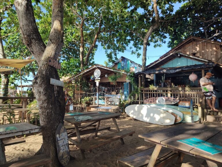 Rua de areia com lojas e artesanato na vila de Caraíva Bahia