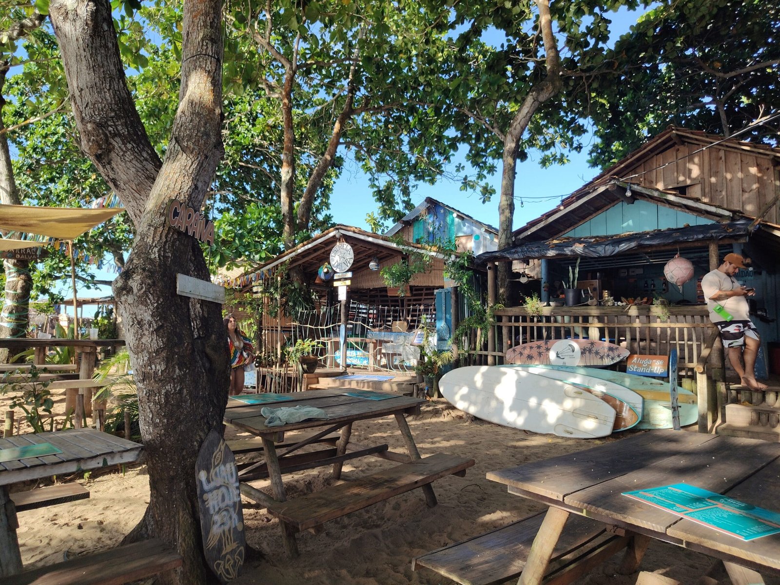 Rua de areia com lojas e artesanato na vila de Caraíva Bahia