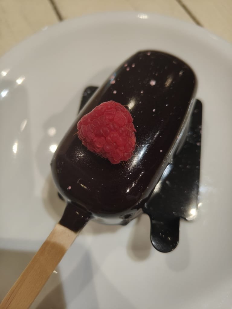 Eataly em São Paulo: Descubra as 7 Verdades Sobre o Espaço Gastronômico Mais Polêmico da Cidade 4 Sobremesa gourmet de chocolate com cobertura espelhada e framboesa fresca servida no Eataly São Paulo