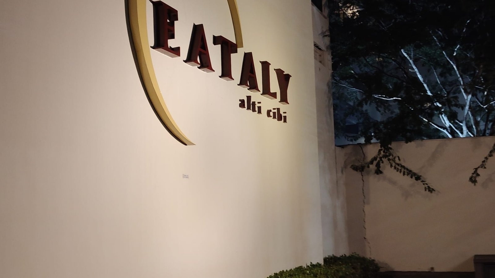 Fachada lateral do Eataly São Paulo iluminada à noite com logotipo clássico em destaque