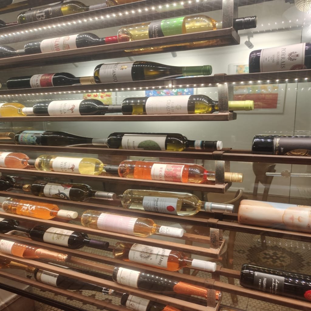 Adega do Jardim Secreto com garrafas de vinhos variados expostas