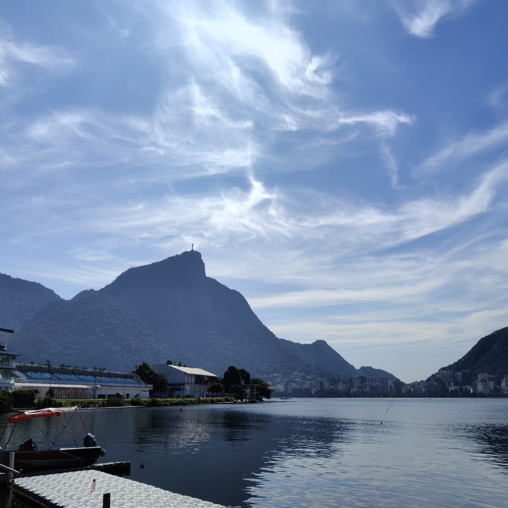 Vista da Lagoa Rodrigo de Freitas com o Cristo Redentor ao fundo em manhã azulada e tranquila no Rio de Janeiro.