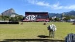 Flamengo’s football field at Gávea, with red-and-black stands and Dois Irmãos mountain in the background on a sunny day