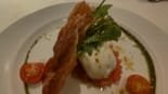Entrada refinada servida no Restaurante Terraço Itália em São Paulo com burrata, rúcula, tomate cereja e massa crocante decorada com azeite e pesto