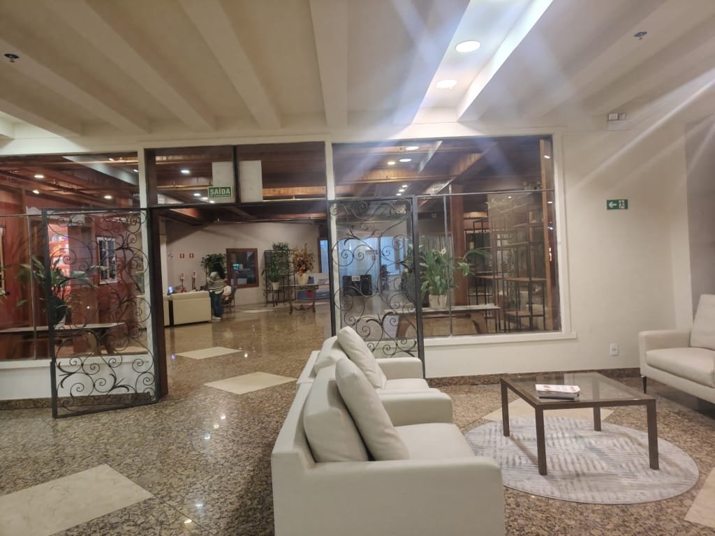 Lobby do Sesc Alpina em julho de 2025, com sofás confortáveis, mesa de centro e entrada elegante com detalhes em ferro e vidro.