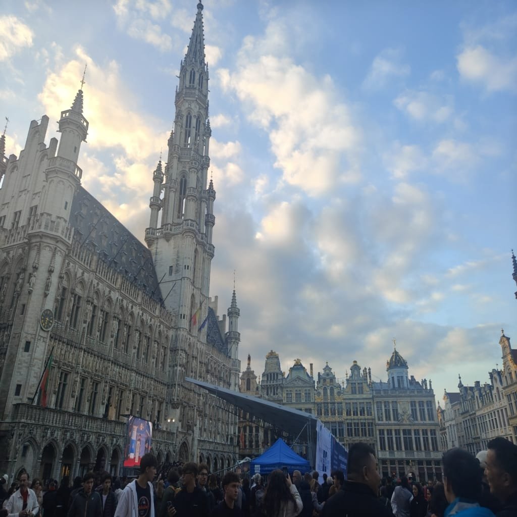 Things to Do in Belgium: Complete Guide with 21 Must-See Experiences✨ 3 View of the Grand Place in Brussels at sunset with historic buildings and crowds of tourists in the square.