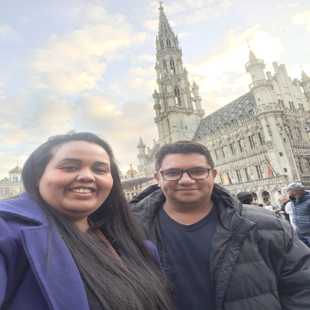 Things to Do in Belgium: Complete Guide with 21 Must-See Experiences✨ 2 Couple smiling at the Grand Place in Brussels with the medieval Town Hall in the background during sunset.