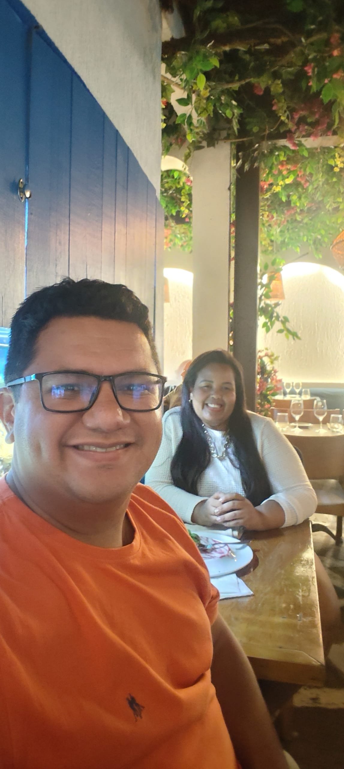 Couple dining at Da Marino in Ipanema, with Mediterranean decor and blue windows.