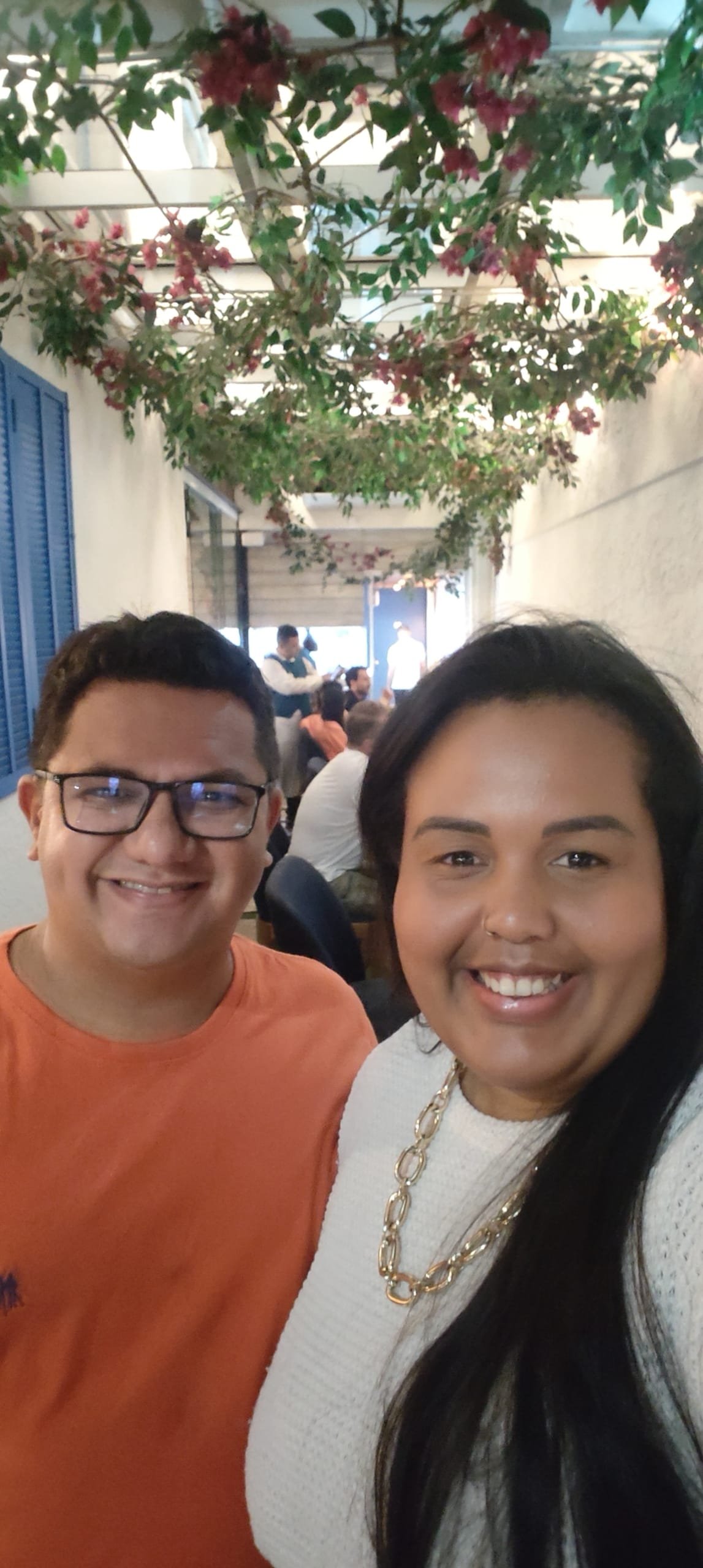 Smiling couple in the flower-lined hallway of Da Marino Ipanema restaurant