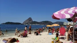 praia do rio de janeiro com pessoas na areia e vista do pão de açúcar