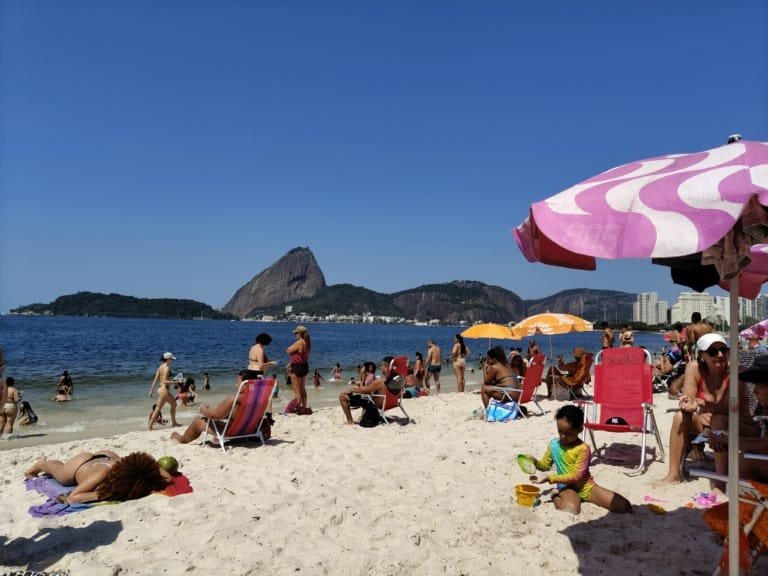 🏖️ Praias do Rio por Estação do Ano: Quando Ir e Vale a Pena? (2026) 12 praia do rio de janeiro com pessoas na areia e vista do pão de açúcar