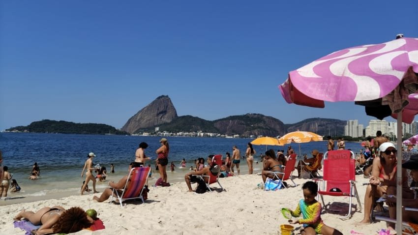 praia do rio de janeiro com pessoas na areia e vista do pão de açúcar