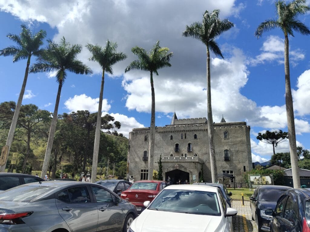 Região Serrana RJ: cidades, roteiros, onde ficar e quando ir 3 Castelo de Itaipava em Petrópolis RJ com palmeiras altas na entrada e fachada medieval