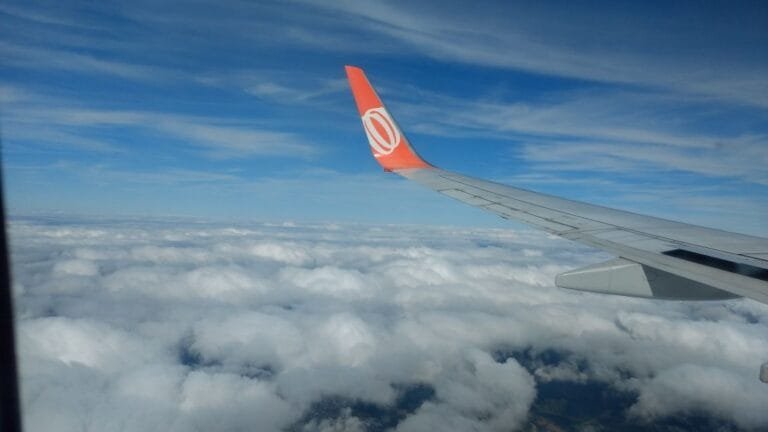 milhas e passagens aéreas: vista da asa do avião acima das nuvens durante voo