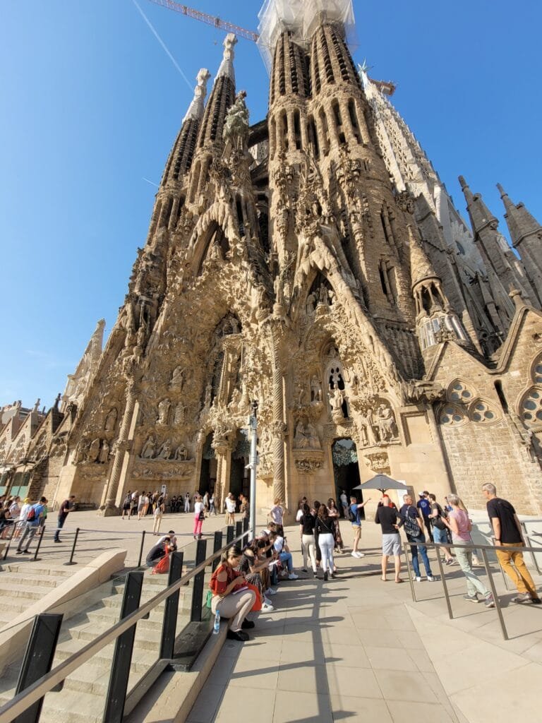 Sagrada Família em Barcelona vista frontal com detalhes da fachada e turistas