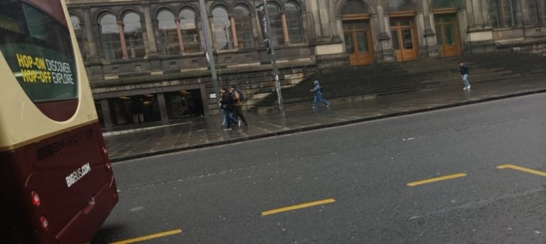 Transporte em Viagens: Como se Locomover com Segurança e Economia no Brasil e no Exterior 2 ônibus turístico hop on hop off em frente a museu histórico representando transporte em viagens internacionais