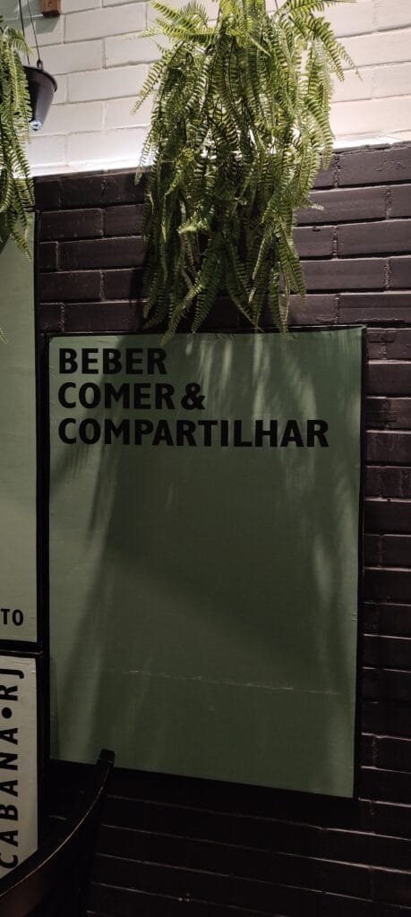 Ambiente do Quintal do Peixoto com frase beber comer e compartilhar na parede