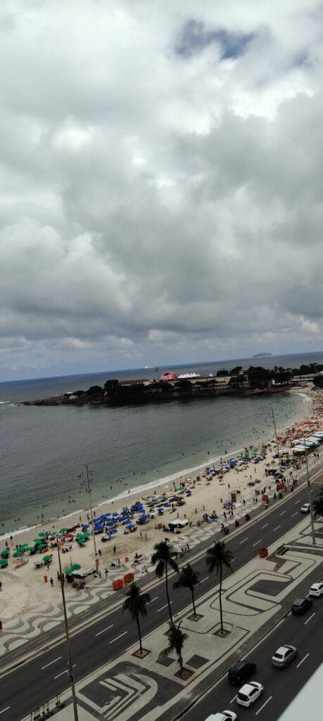 orla de copacabana cheia vista de cima com mar e pr&eacute;dios do rio de janeiro