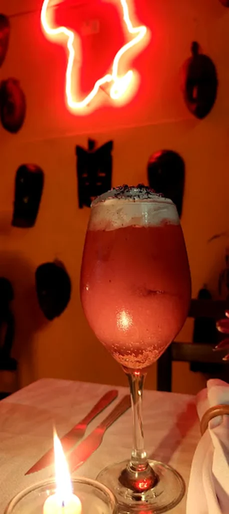 Dida Bar no Rio: vale a pena conhecer o restaurante africano da Lapa? 8 Drink no Dida Bar com neon da África ao fundo no Rio de Janeiro