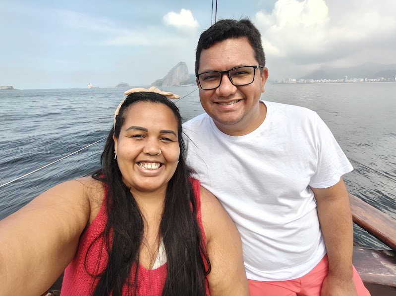 O Que Fazer no Rio de Janeiro: Guia Completo com Roteiros, Praias, Museus e Experiências 3 Casal durante passeio de barco pela Baía de Guanabara, com o Pão de Açúcar ao fundo no Rio de Janeiro