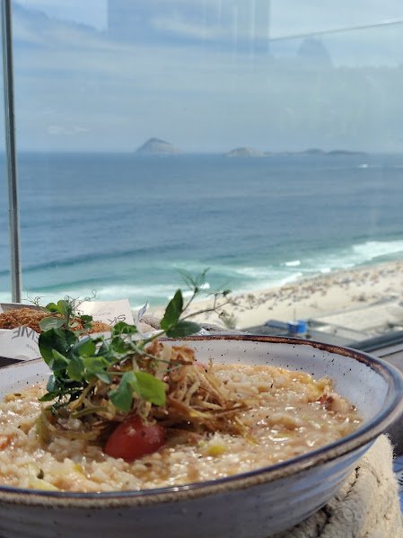 Restaurantes no Rio de Janeiro: Guia Completo para Comer Bem em 2026 2 Risoto servido no SKY Leme com vista para a Praia do Leme no Rio de Janeiro