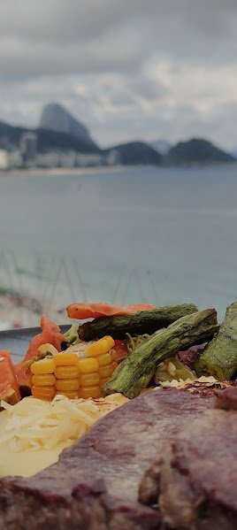 Restaurantes no Rio de Janeiro: Guia Completo para Comer Bem em 2026 3 Prato servido no Vizta Rooftop com vista de Copacabana e do Pão de Açúcar no Rio de Janeiro